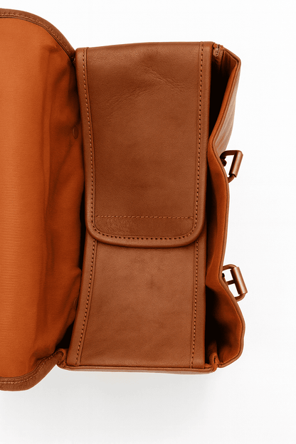 Brown leather bag with a flap on a white background